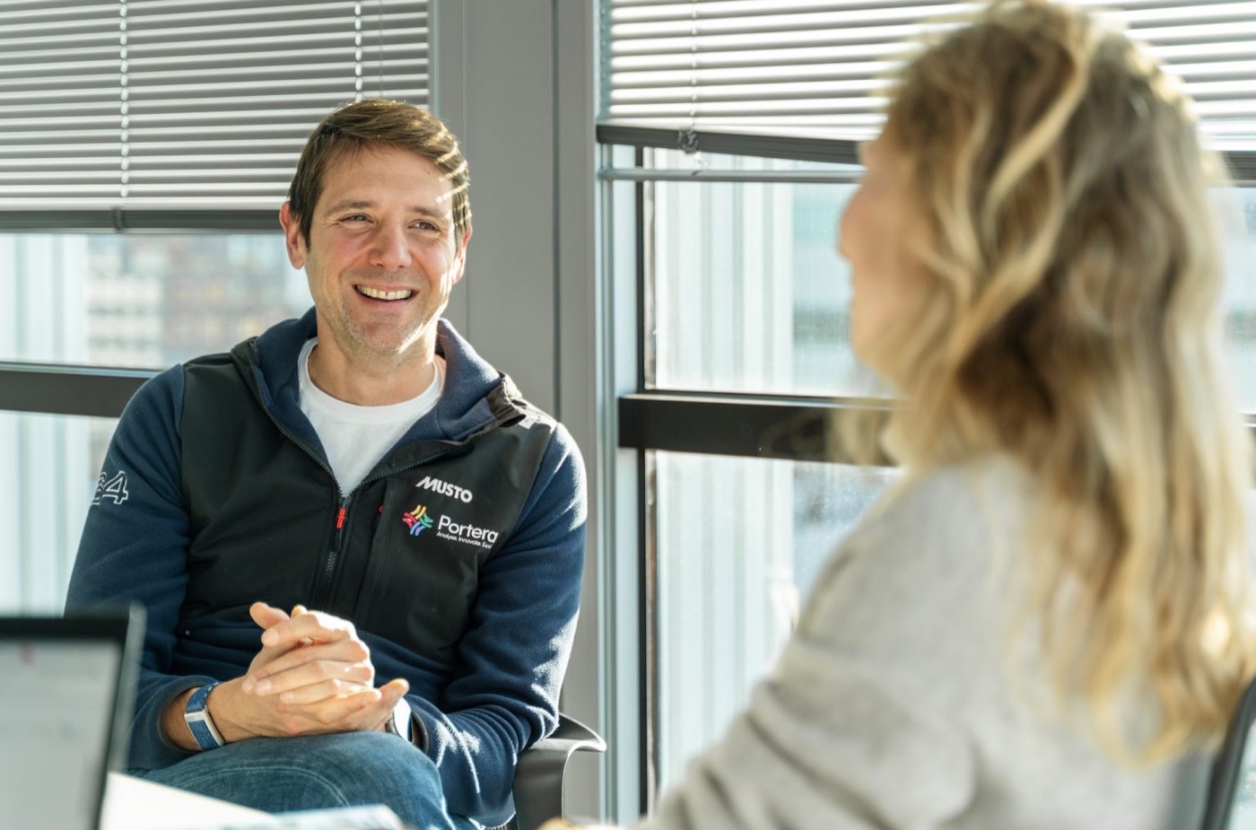 A sailor in a Portera team jacket smiling in conversation
