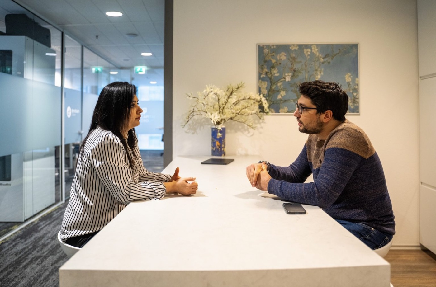 Two colleagues in conversation across a meeting table